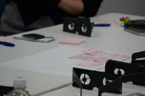 写真：机上に置かれた弱視体験用メガネと、メモが取られている付箋